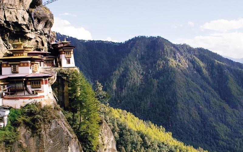 Beautiful Bhutan landscape with Himalayan mountains, traditional Bhutanese monastery, and colorful prayer flags